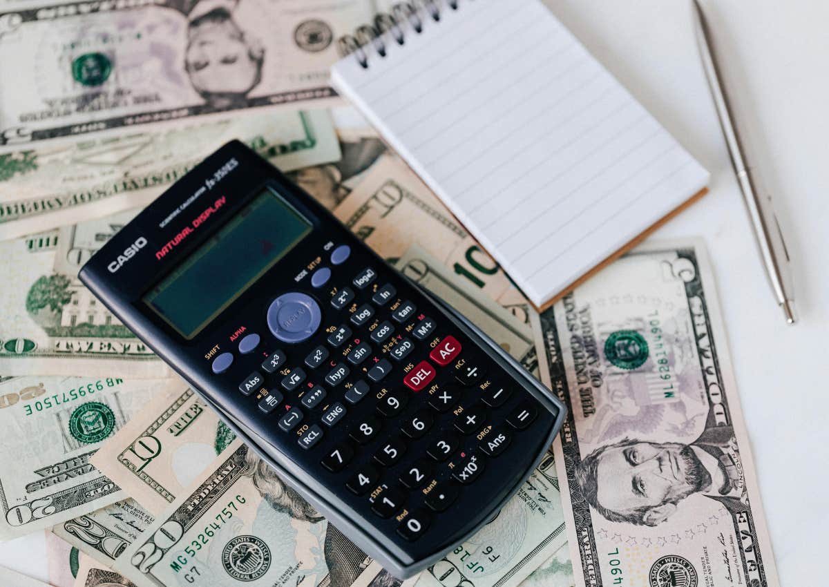 Calculator and notepad on top of money